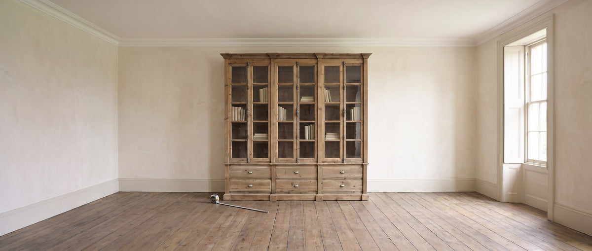 Styled visualization of the Pine Bookcase Large 6 Door (LD13-NA) in a high-ceilinged room