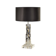 Tall cylindrical acrylic lamp with twigs encased, topped by round shade
