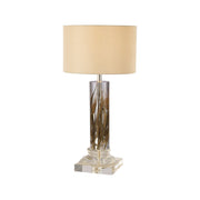 Tall cylindrical acrylic lamp with dried wheat stems inside and shade