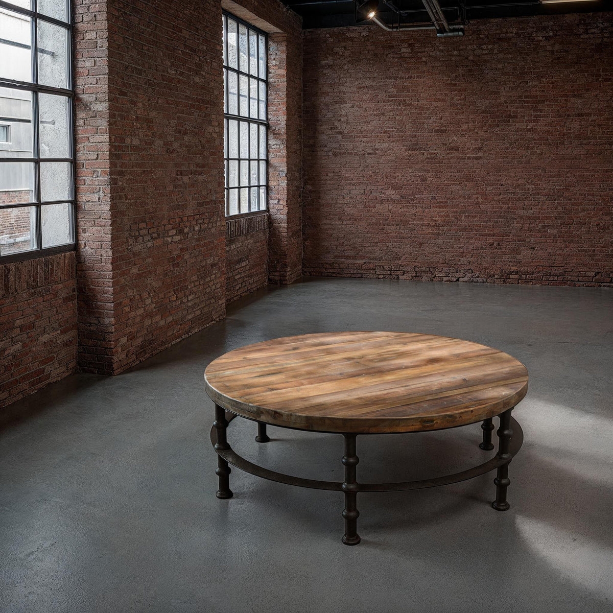 Round reclaimed pine coffee table with plank top on a turned iron base