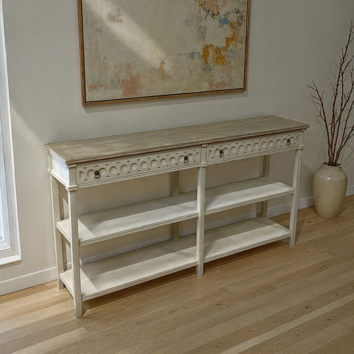 Painted-wood console table with cutwork apron, drawers and open shelf