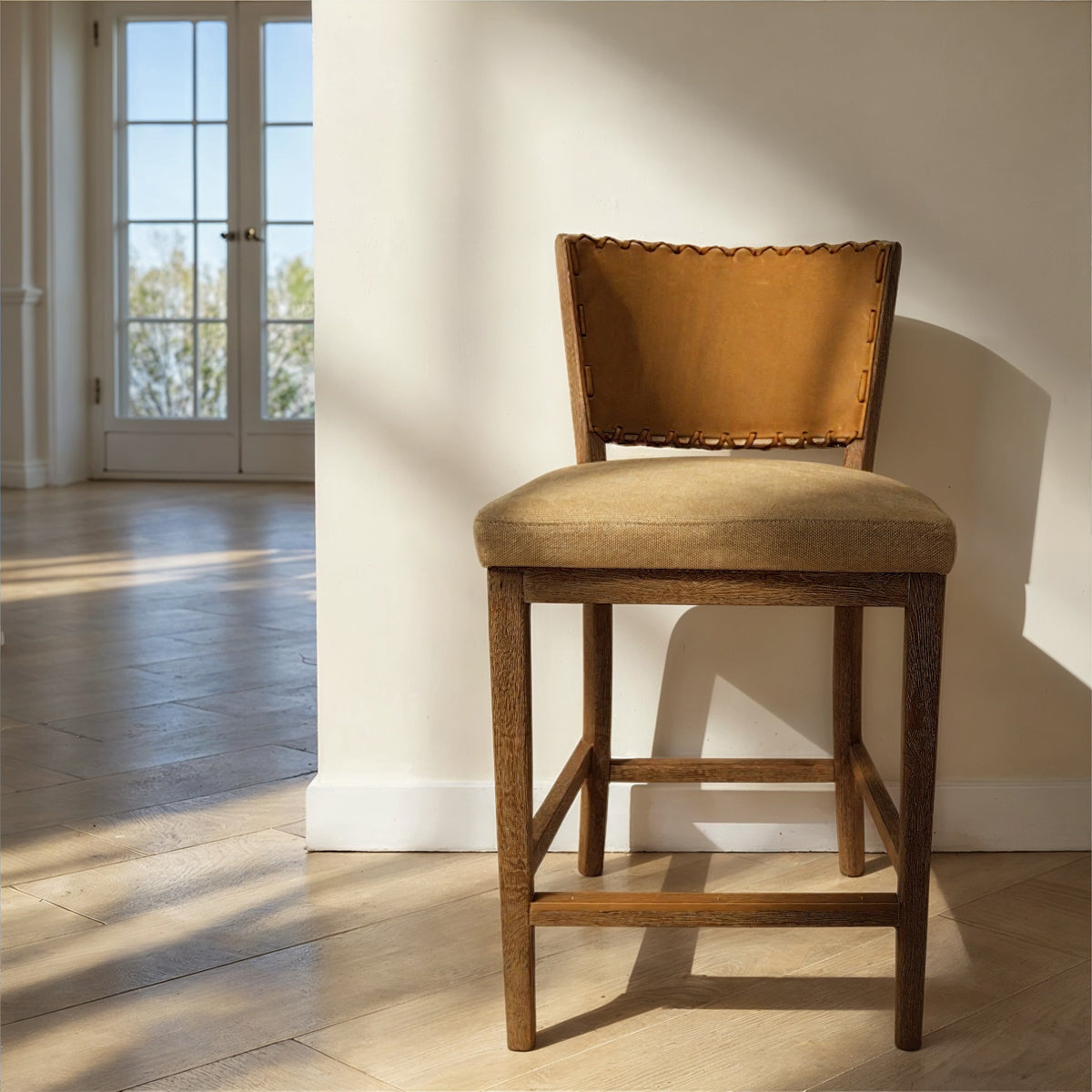 Armless counter chair with a brown leather back and seat on an oak frame