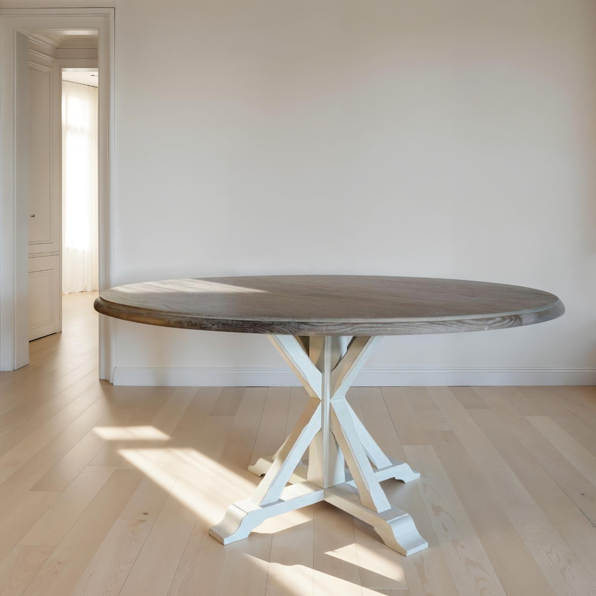 Round oak dining table in light burnt finish on an intersecting base