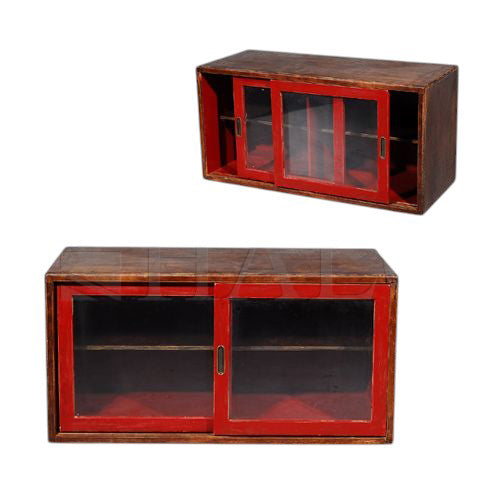 Low wood cabinet in layered semaphore red with sliding glazed doors