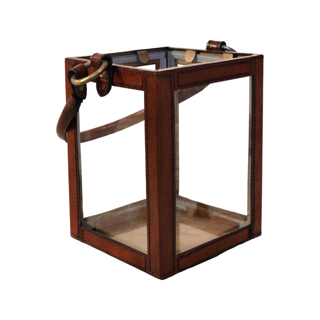 Small hurricane lantern with a brass frame, glass panels, and leather straps