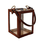 Medium hurricane lantern with a brass frame, glass panels, and leather straps