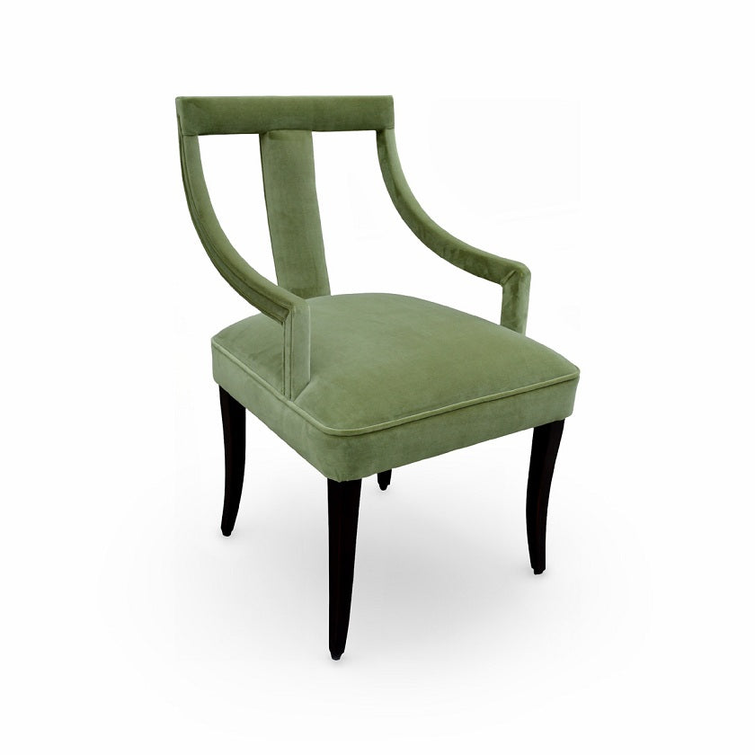 Arm chair upholstered in green velvet with curved arms on a birch frame