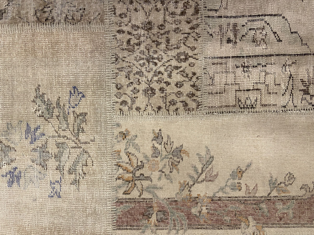 Vintage Turkish patchwork rug with pale floral and geometric remnants.