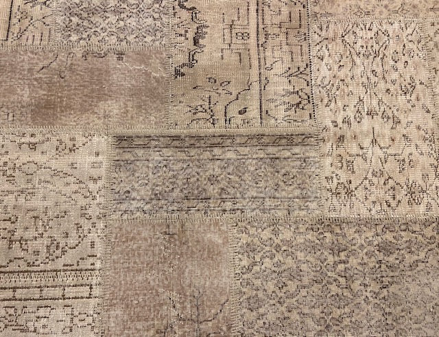 Vintage Turkish patchwork rug in muted, evenly faded wool tones.