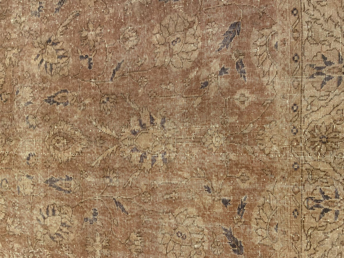 Softly worn handwoven Turkish wool rug in warm, subdued tones.