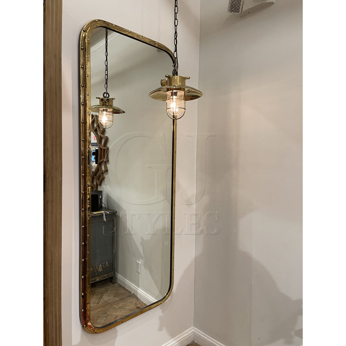 Overscaled mirror set in a salvaged brass ship porthole with patina