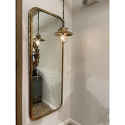 Overscaled mirror set in a salvaged brass ship porthole with patina