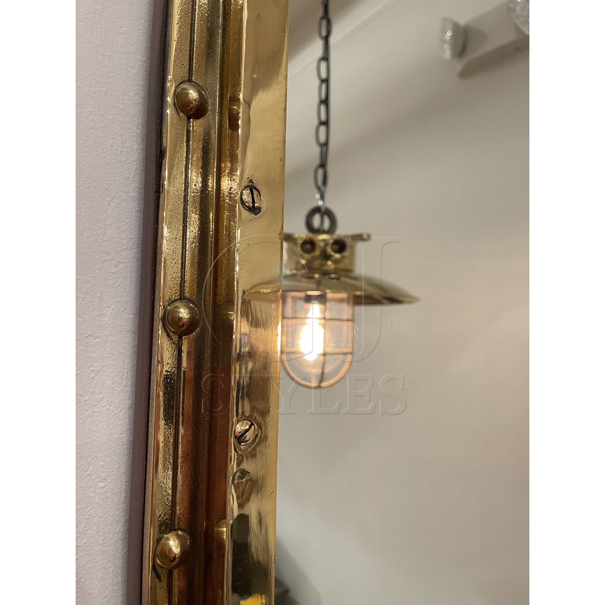 Overscaled mirror set in a salvaged brass ship porthole with patina
