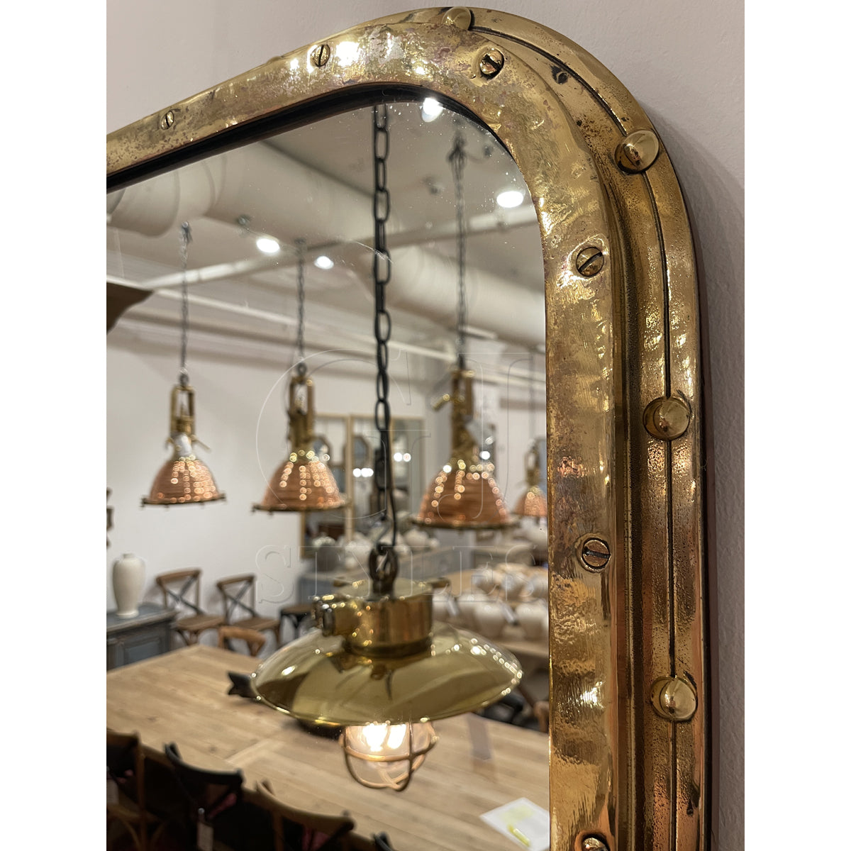 Overscaled mirror set in a salvaged brass ship porthole with patina