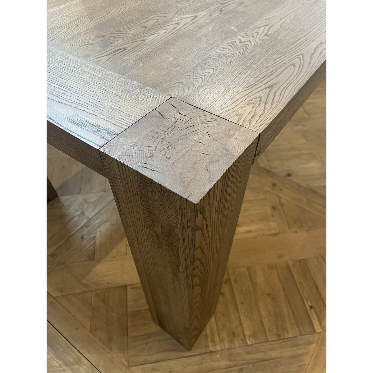 Oak dining table with chestnut detailing on a rectilinear base