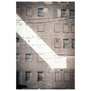 Photograph of a weathered brick facade with windows and string lights