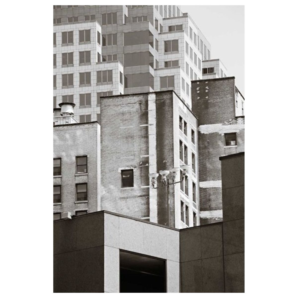 Monochrome photograph of layered old and new city building facades