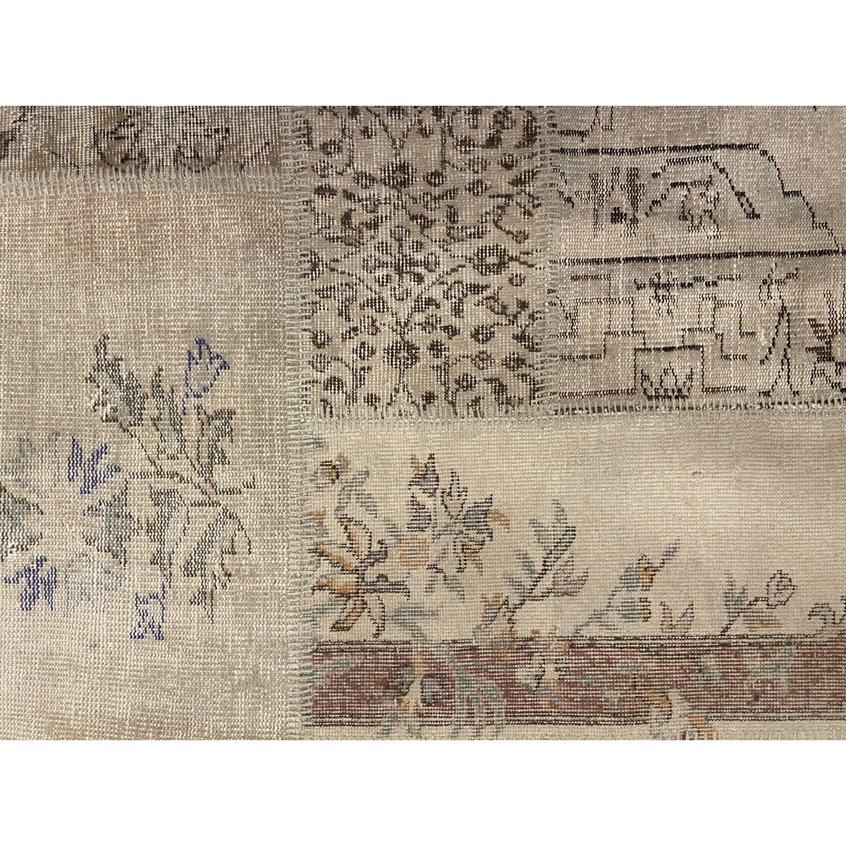 Vintage Turkish patchwork rug with pale floral and geometric remnants.